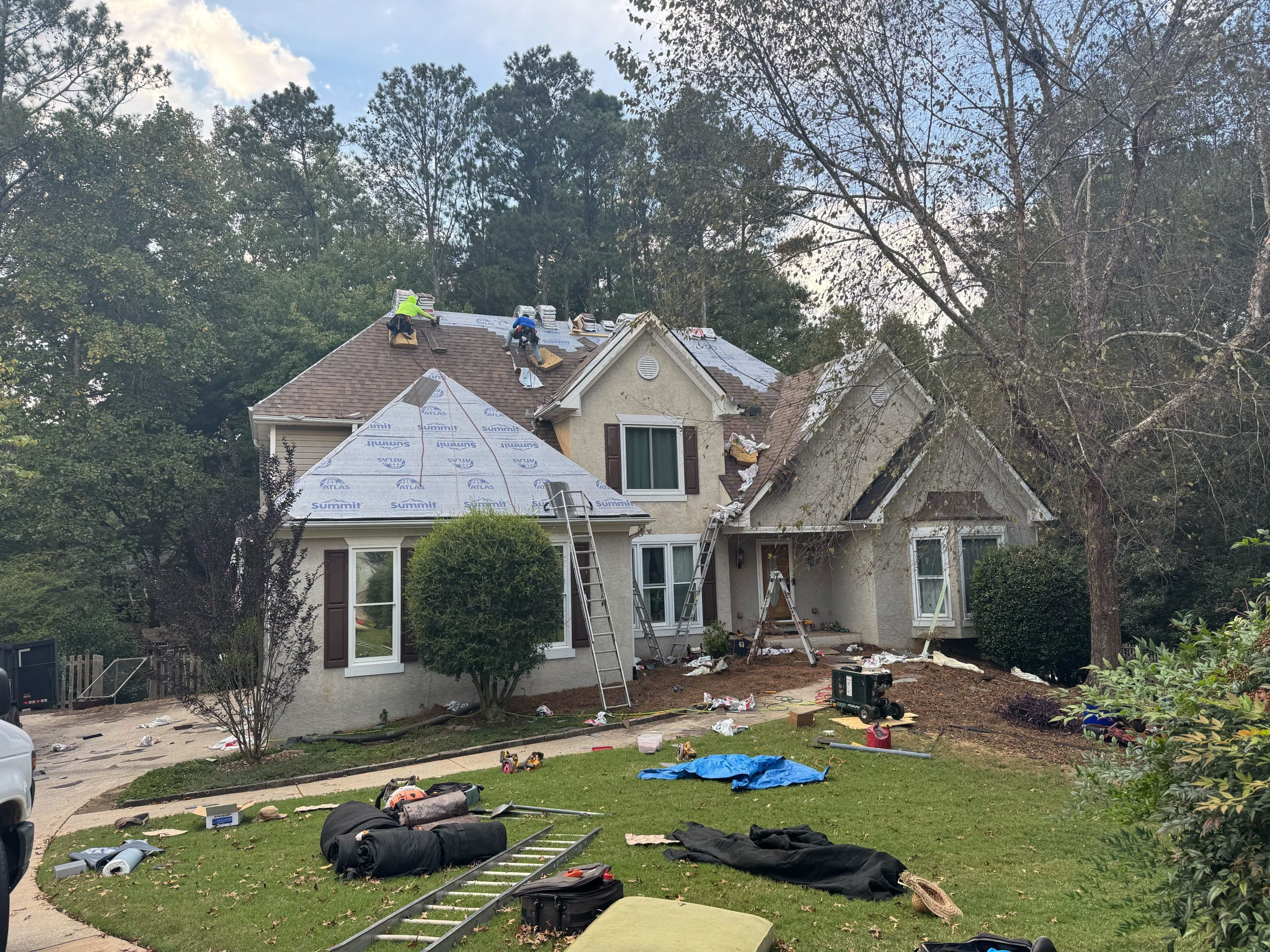 Roofers on a house with during a roof replacement