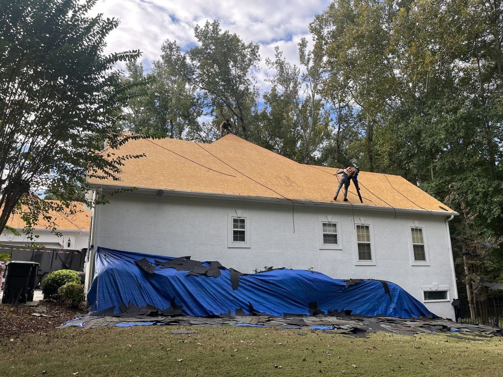 Roofers on a house with during a roof replacement
