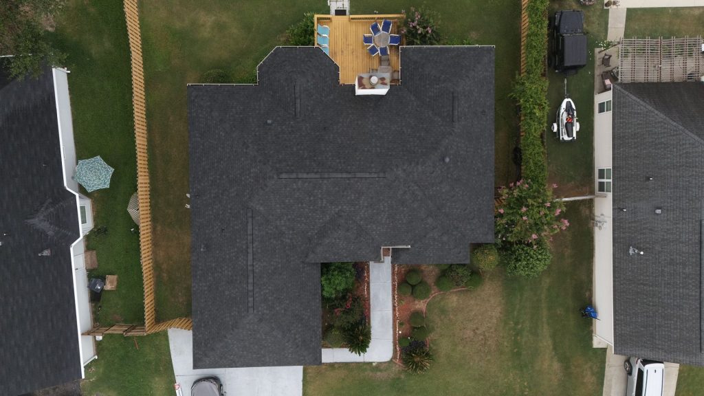 Top down Image of a new dark gray asphalt shingled roof replacement on a house.