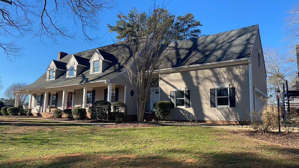 House with asphalt shingles before a metal roof replacement
