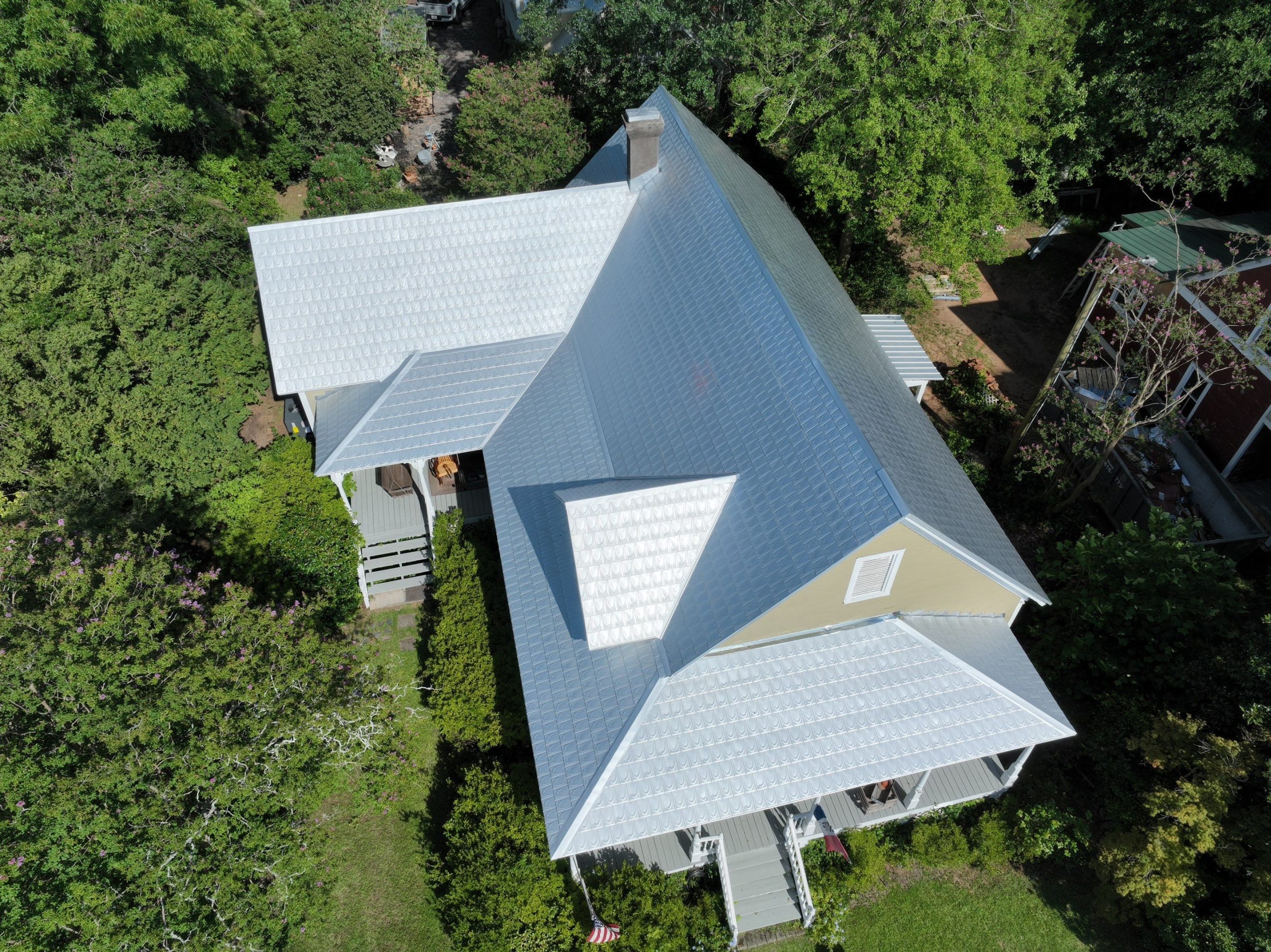 Drone photo of a house after a silver metal roof replacement