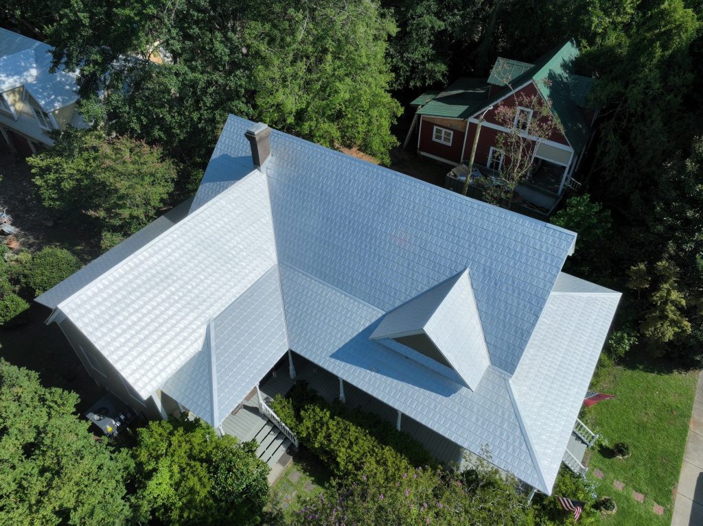 Drone photo of a house after a silver metal roof replacement